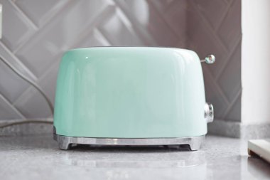 Gri taş mutfak tezgahında yeşil ekmek kızartma makinesi