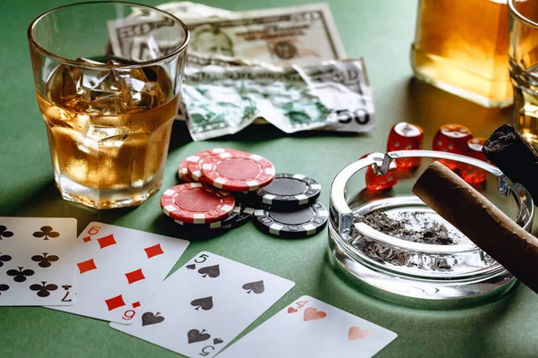 Glas whisky, sigaar, speelkaarten en chips op groene achtergrond — Stockfoto