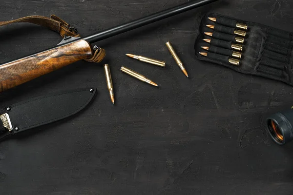 Fucile da caccia e cartucce su sfondo di legno scuro — Foto Stock