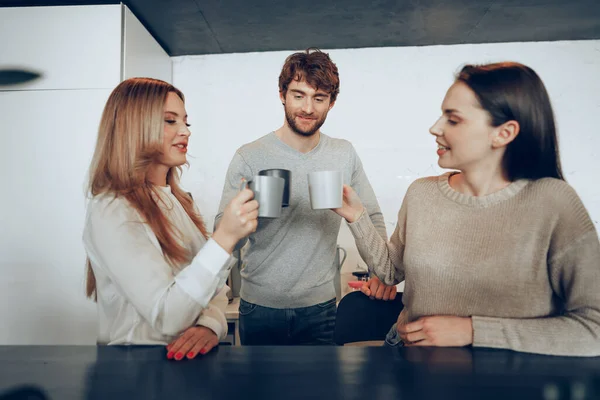 Jóvenes empresarios colegas tomando un café en la oficina, bebiendo y hablando — Foto de Stock