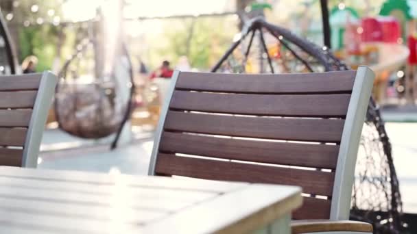 Siège vide et table en bois dans un café extérieur — Video
