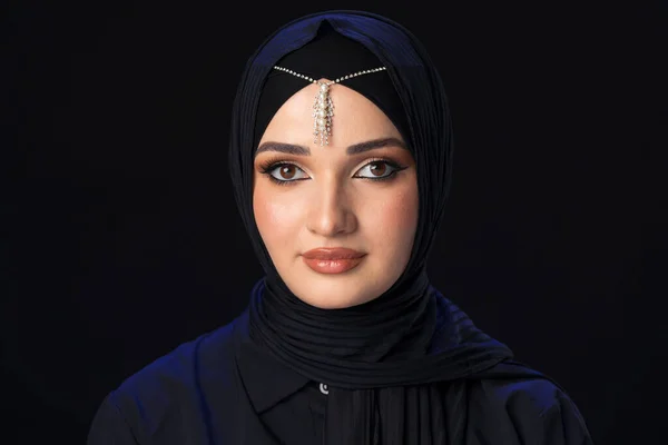 一个身披头巾、背景为黑色的年轻穆斯林妇女的画像 — 图库照片