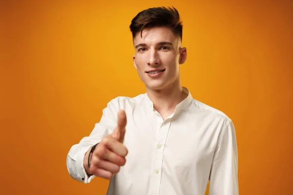Mladý muž ukazující značku OK na žlutém pozadí — Stock fotografie