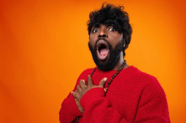 Heyecanlı genç siyah adam sarı arka planda çığlık atıyor.