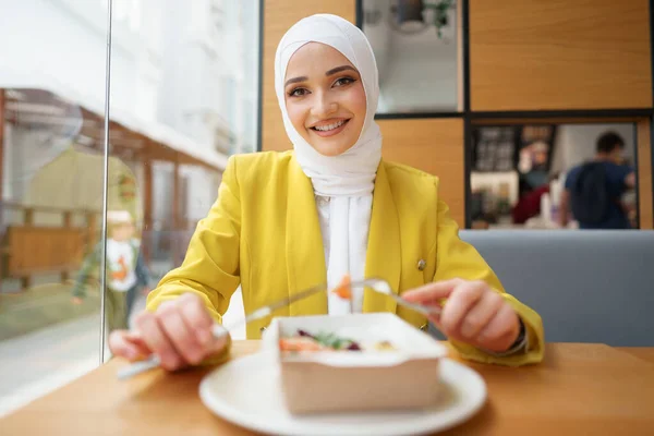 Jonge moslim vrouw in hijab lunchen in café — Stockfoto