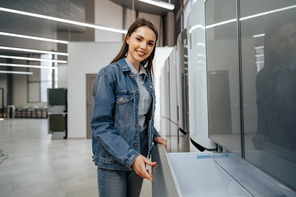 Ung attraktiv kvinna väljer kylskåp i hypermarket — Stockfoto