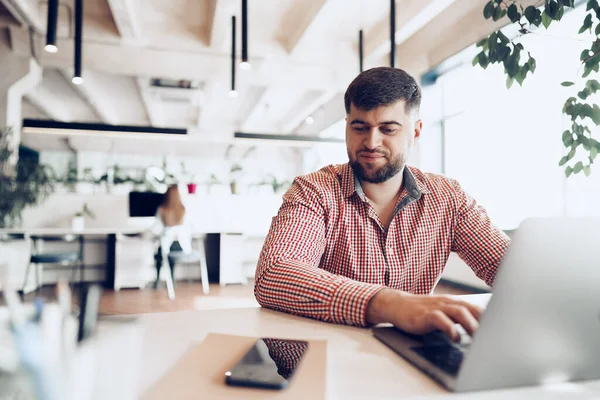Junger Mann im lässigen Hemd arbeitet im Büro am Computer — Stockfoto