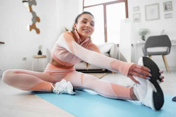 Young fit woman doing stretching exercises at home — Stock Photo, Image