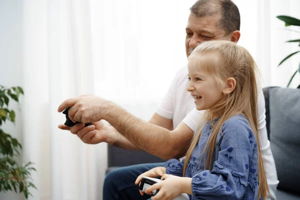 Avô e neta jogando videogames em casa. — Fotografia de Stock