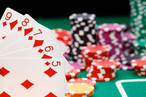 Playing cards and chips on green casino table background