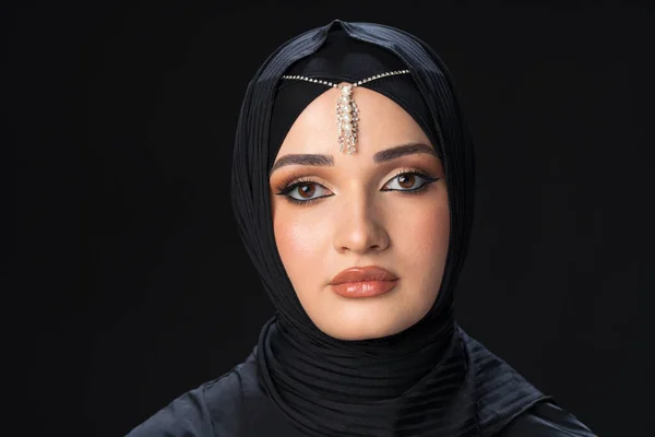 Portrait of a young muslim woman in hijab on black background — Stock Photo, Image