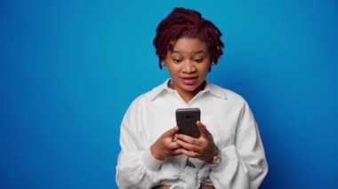 Başarılı afro kadın akıllı telefondan iyi haberler aldı ve yumruğunu sıktı.
