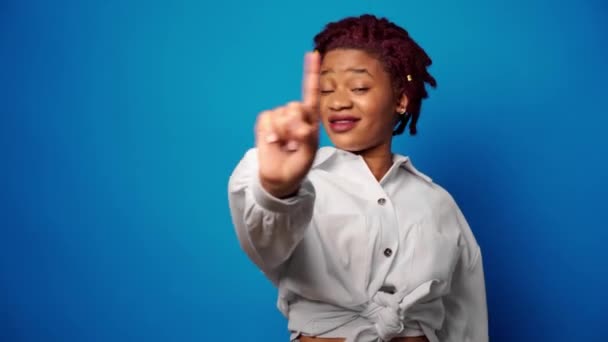 Dissatisfied afro american woman showing her refusal, denies something against blue background — Stock Video