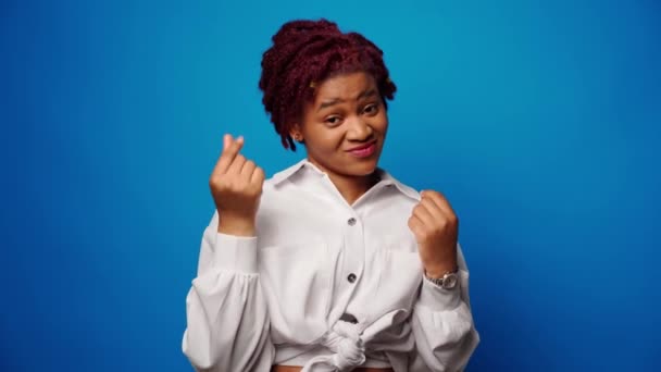 Pozitivní africká žena předstírá házení bankovek, utrácet peníze na modrém pozadí — Stock video