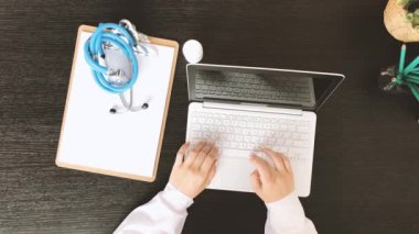 Dizüstü bilgisayarda yazı yazan kadın doktorların üst görüntüsü