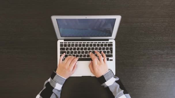 Ovanifrån av kvinnliga händer skriva på laptop på svart träbord — Stockvideo