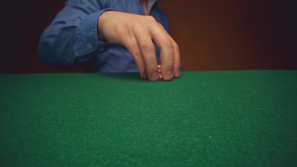 Man speler verplaatsen casino chips op poker tafel close-up — Stockvideo