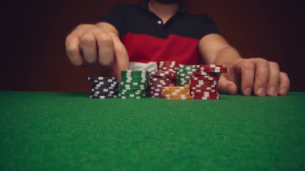 Erkek oyuncu poker masasında kumarhane fişlerini taşıyor. — Stok video