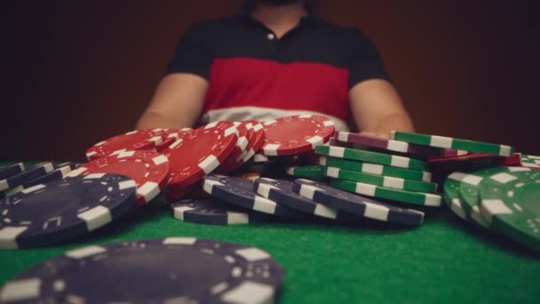Man speler verplaatsen casino chips op poker tafel close-up — Stockvideo