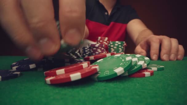 Man speler verplaatsen casino chips op poker tafel close-up — Stockvideo