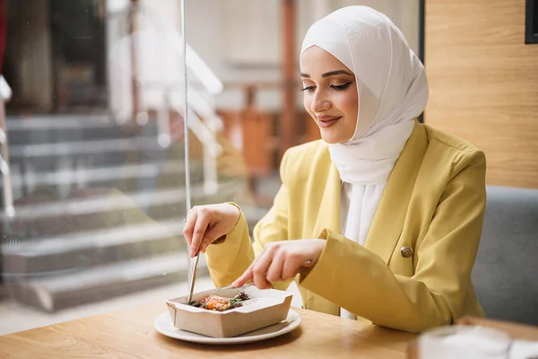 Jonge moslim vrouw in hijab lunchen in café — Stockfoto