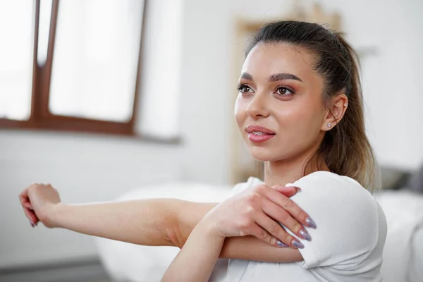 Joven mujer en forma haciendo ejercicios de estiramiento en casa —  Fotos de Stock