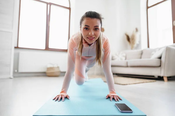 Sporty young woman doing plank exercise indoors at home — Stock Photo, Image