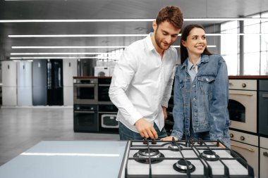 Mutlu gülümseyen çift hipermarketten yeni ev aletleri aldı.