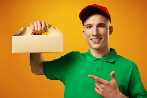Persona de entrega que sostiene el paquete con entrega de alimentos sobre fondo amarillo —  Fotos de Stock