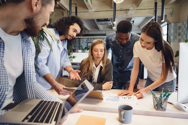 Team unterschiedlicher Mitarbeiter in modernem Büro bespricht gemeinsam ihr Projekt — Stockfoto