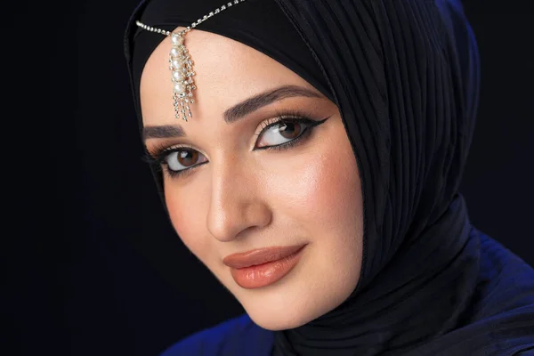 Portrait of a young muslim woman in hijab on black background — Stock Photo, Image