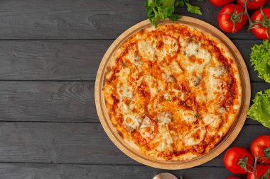 Siyah ahşap arka plan manzaralı lezzetli pizza.