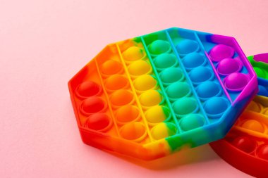 Renkli anti-stres oyuncağını pembe arka plana yerleştir