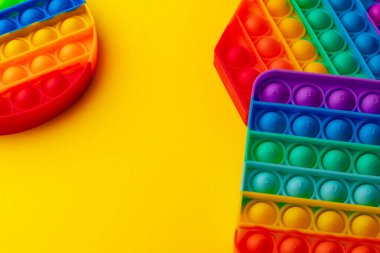 Renkli anti-stres oyuncağını sarı arka plana yerleştir