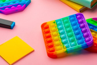Renkli anti-stres oyuncağını pembe arka plana yerleştir