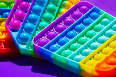 Renkli anti-stres oyuncağını mor arka plana yerleştir