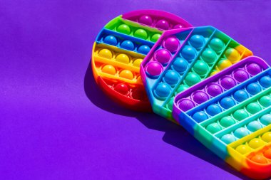 Renkli anti-stres oyuncağını mor arka plana yerleştir