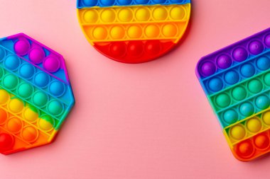 Renkli anti-stres oyuncağını pembe arka plana yerleştir
