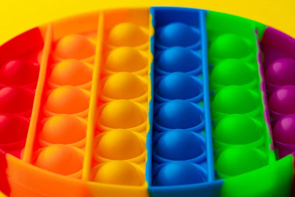 Renkli anti-stres oyuncağını sarı arka plana yerleştir — Stok fotoğraf