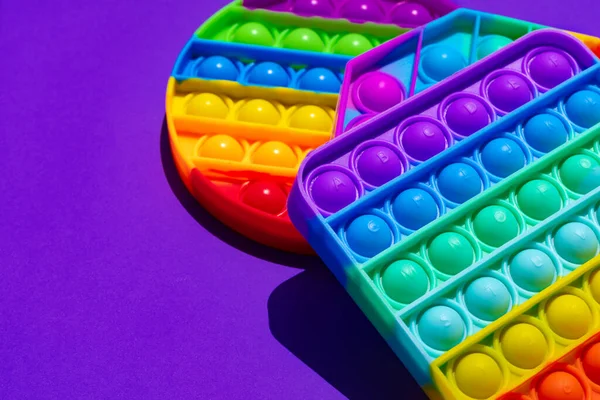 Renkli anti-stres oyuncağını mor arka plana yerleştir — Stok fotoğraf