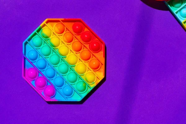 Renkli anti-stres oyuncağını mor arka plana yerleştir — Stok fotoğraf