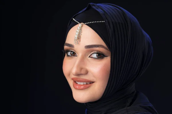 Portrait of a young muslim woman in hijab on black background — Stock Photo, Image