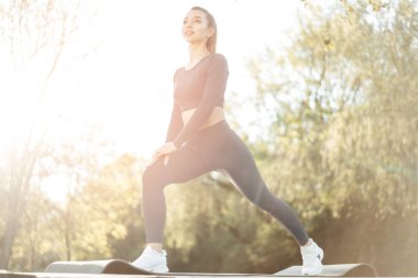 Parkta paspas üzerinde egzersiz yapan zinde bir genç kadın.