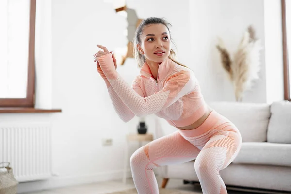 Молодая девушка фитнес делать спортивные упражнения в своей гостиной на дому — стоковое фото