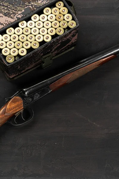 Κυνηγετικό όπλο και φυσίγγια σε σκούρο ξύλινο φόντο — Φωτογραφία Αρχείου