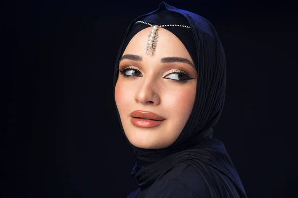 Portrait of a young muslim woman in hijab on black background — Stock Photo, Image