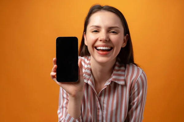 Χαρούμενη χαμογελαστή νεαρή γυναίκα που σας δείχνει μαύρη οθόνη smartphone με χώρο αντίγραφο — Φωτογραφία Αρχείου