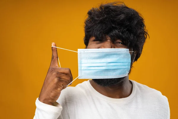Positivo guapo afroamericano hombre con máscara médica contra fondo amarillo —  Fotos de Stock