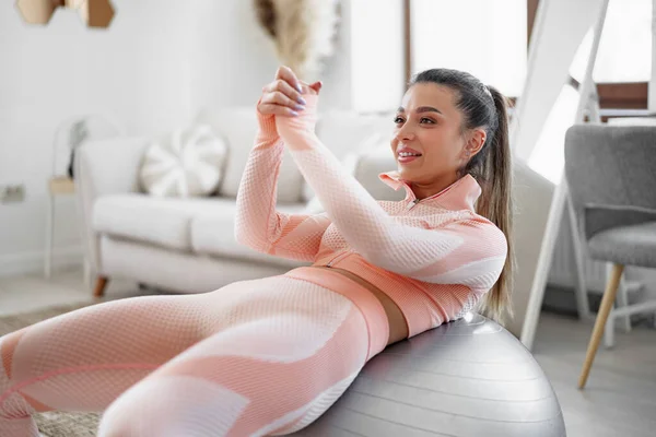 Sportieve vrouw doet buikspieroefeningen op fitness bal thuis — Stockfoto