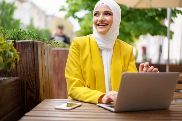 Mooie glimlachende moslim vrouw met laptop in cafe — Stockfoto